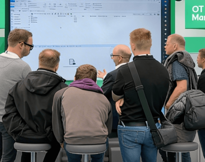 Bechtle PLM Rundgang Hannover Messe Personen stehen im Kreis für eine Demonstration am Bechtle Stand